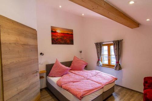 een slaapkamer met een bed met roze lakens en een raam bij Ferienwohnung Hilde in Miesbach