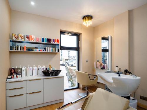 a bathroom with a sink and a toilet and a window at Laurasapartment in Jarosławiec