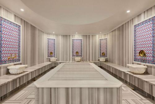a dressing room with three sinks and three windows at Ramada Plaza by Wyndham Silivri in Silivri