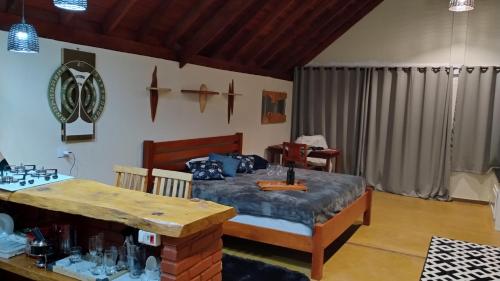 sypialnia z łóżkiem i stołem w obiekcie Chales Sabor Dos Ventos w mieście Gonçalves