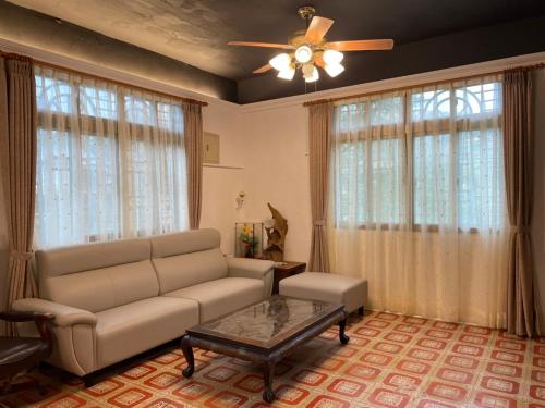 a living room with a couch and a ceiling fan at Jiufen Gourd Stone TreeHouse 137 in Ruifang