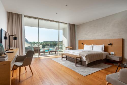 um quarto de hotel com uma cama e uma varanda em Hiddenbay Teos Sığacık Hotel, Spa and Restaurants em Seferihisar