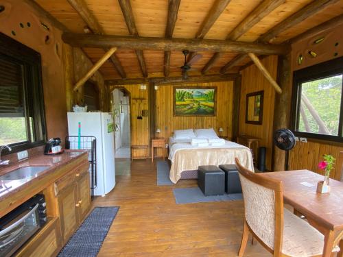 1 dormitorio en una cabaña con 1 cama y cocina en Cabana com vista para o canyon, en Praia Grande
