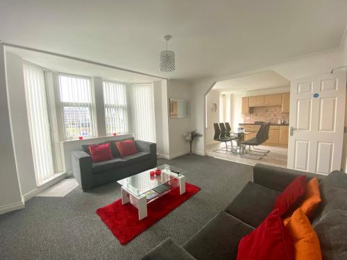 a living room with a couch and a table at Fabrik Apartments - Harrowside by Blackpool Service Apartements in Blackpool