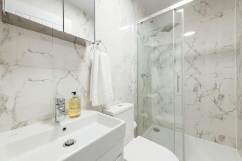 a bathroom with a sink and a toilet and a shower at Stylish 2 Bedroom Flat in Ilford, London in Ilford