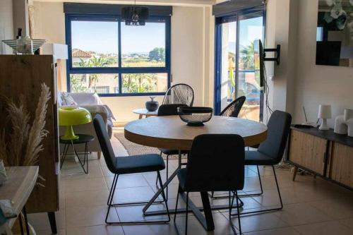 een eetkamer met een tafel en stoelen in een kamer bij Coqueto apartamento con vistas al mar in Denia