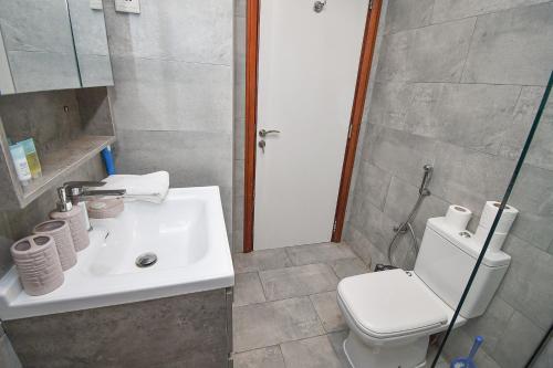ein Bad mit einem Waschbecken und einem WC in der Unterkunft Cozy 1 Bedroom with Study room in Dubai Marina - Ideal for 3 Guests - PRK in Dubai