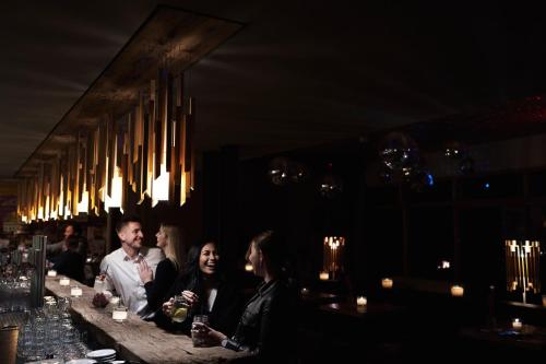 a group of people sitting at a bar at Holzhotel Forsthofalm in Leogang