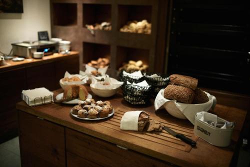 a table with different types of bread and pastries on it at Holzhotel Forsthofalm in Leogang