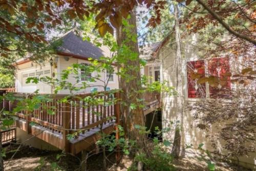 a white house with a porch and a tree at Annandale - V067 in Lake Arrowhead