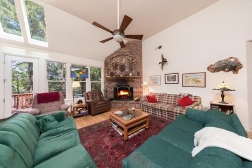 a living room with a green couch and a fireplace at Annandale - V067 in Lake Arrowhead