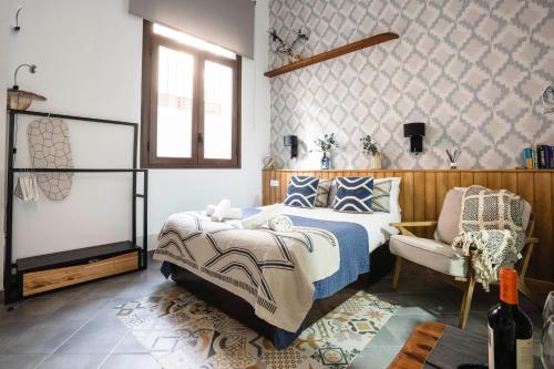 マラガにあるEdificio Conde 7- Plaza de la Mercedのベッドルーム1室(ベッド1台、椅子付)