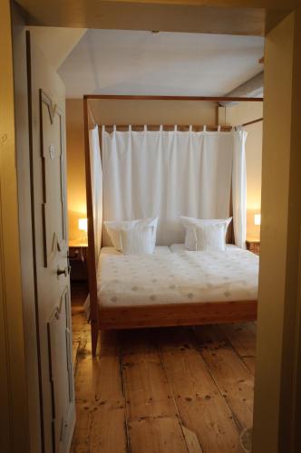 a bedroom with a canopy bed with two pillows at Hotel am Hoken in Quedlinburg