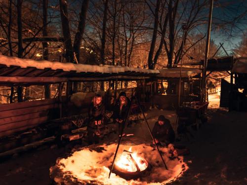 eine Gruppe von Menschen, die um ein Feuer stehen in der Unterkunft Kolejarz Best For You SPA in Ustroń