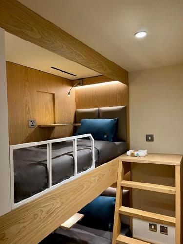 a bunk bed with a couch in a room at Sleepover Doha North Node - formerly sleep 'n fly in Doha