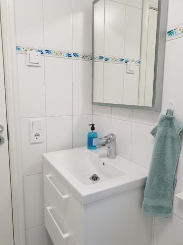 La salle de bains blanche est pourvue d'un lavabo et d'un miroir. dans l'établissement Sjöutsikten, à Gränna