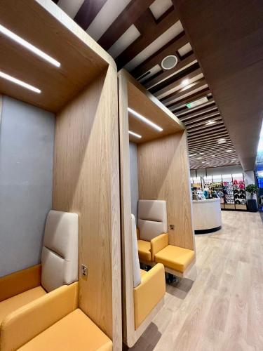 a waiting room with yellow seats in a store at Sleepover Doha North Node - formerly sleep 'n fly in Doha