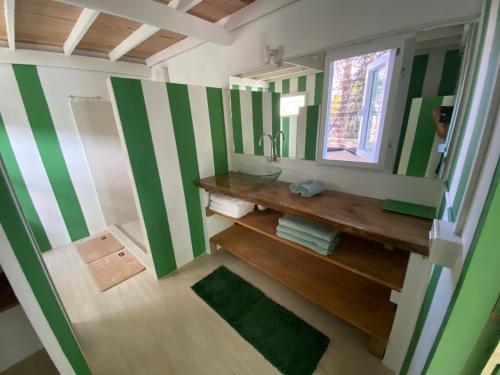 a bathroom with green and white stripes on the walls at Beach house in Baan Tai