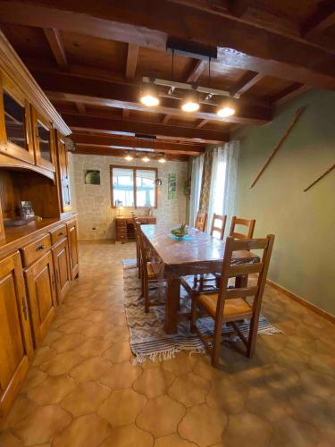 a dining room with a wooden table and chairs at Maison 6 personnes avec piscine terrain arboré clôturé in Vallabrix