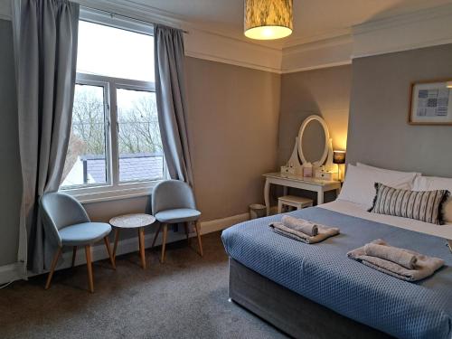 a bedroom with a bed and a mirror and a window at Llandudno apartment, quirky pub with tropical beer garden in Llandudno