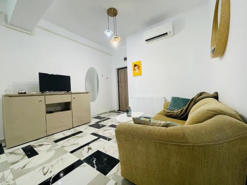 een woonkamer met een bank en een tv bij Family apartment near Palas Mall in Iaşi