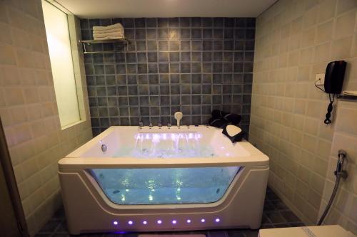 a bathroom with a tub filled with water in it at Humming Bird Hotel & Banquet in Anand