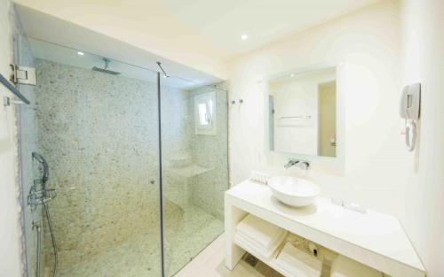 a bathroom with a sink and a glass shower at Marpunta Resort, Santikos Collection in Patitiri