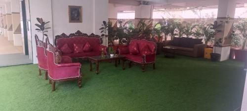 a living room with red chairs and a table at UNIQUE HOMESTAYS in Kondapur