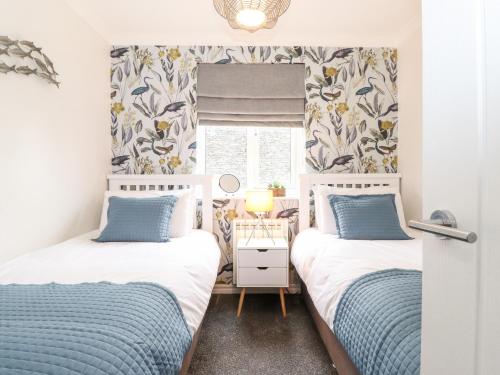 2 camas en una habitación pequeña con ventana en Bluebell Hill, en Windermere