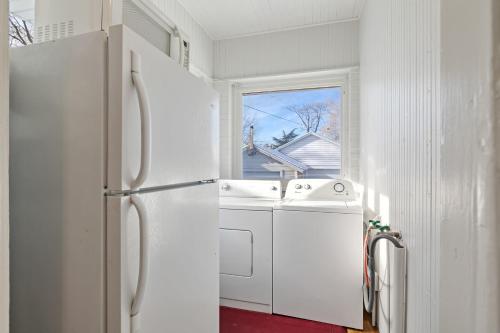 a white kitchen with a refrigerator and a sink at 2 Bedroom Near Trolley Square and Liberty Park! in Salt Lake City