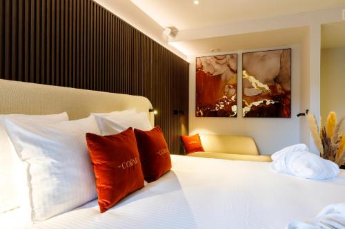 ein Hotelzimmer mit einem Bett mit roten und weißen Kissen in der Unterkunft The CORNR Hotel in Nieuwpoort