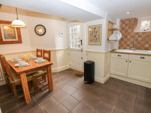 a kitchen with a table and chairs and a sink at Buttercup Cottage in Bakewell