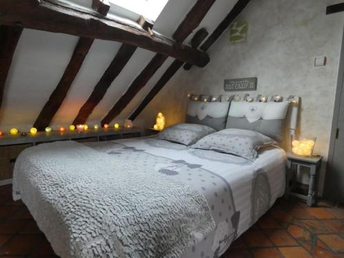Un dormitorio con una cama blanca con luces. en Charming house - Beauval - Loire Valley, en Saint-Cyran-du-Jambot