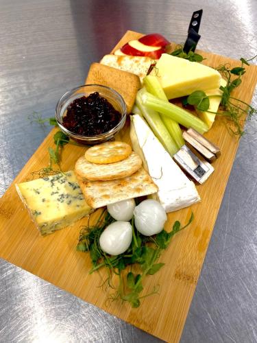 a cutting board with cheese and other foods on it at Bells Hotel in Coleford