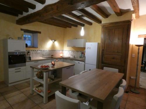 uma cozinha com uma mesa de madeira e electrodomésticos brancos em Charming house - Beauval - Loire Valley em Saint-Cyran-du-Jambot