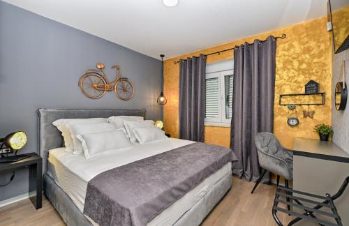 a bedroom with a bed and a desk and a bike on the wall at Art Spa Zeus in Pula