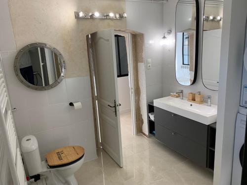 a bathroom with a sink and a toilet and a mirror at L'Appartement de La Mouline in Pézenas