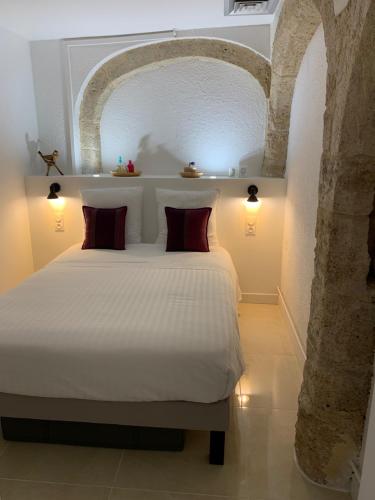 a bedroom with a white bed with an archway at L'Appartement de La Mouline in Pézenas