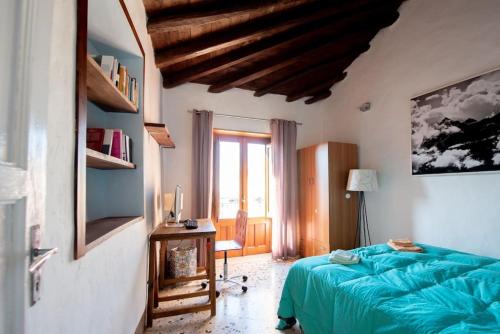 Un dormitorio con una cama azul y una ventana en Casa degli Ospiti, en Alimena