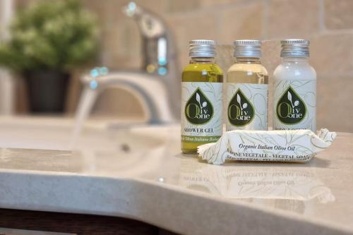 three bottles of essential oils sitting on a bathroom counter at [Raffinata Dimora] Wi-fi Parcheggio Privato Balcone Abitabile in Porto SantʼElpidio