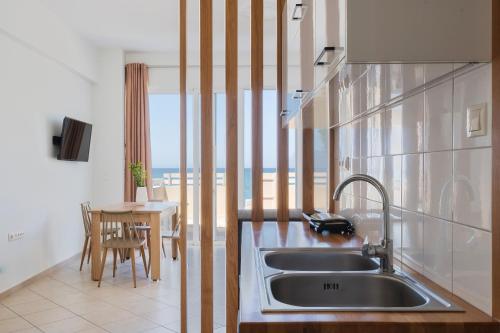a kitchen with a sink and a view of the ocean at Wink Bnb Paraliaki in Kissamos