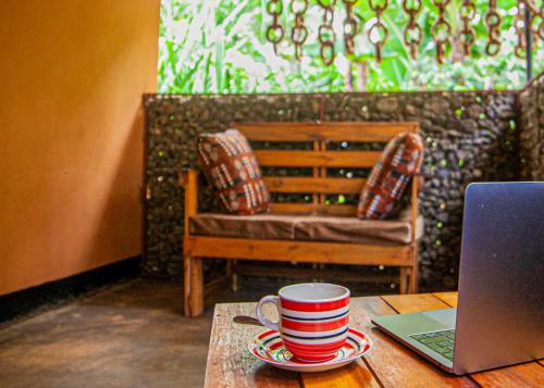 a cup of coffee on a table with a laptop at Materuni Homes in Moshi