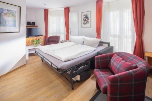 ein Schlafzimmer mit einem Bett, einem Sofa und einem Stuhl in der Unterkunft Lüttji Dame 3 in Norderney