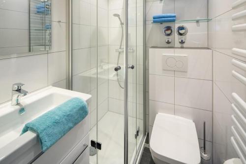 ein Bad mit einer Dusche, einem WC und einem Waschbecken in der Unterkunft Lüttji Dame 3 in Norderney