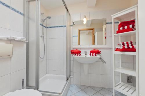 ein weißes Badezimmer mit Dusche und Waschbecken in der Unterkunft Haus Friederike in Norderney