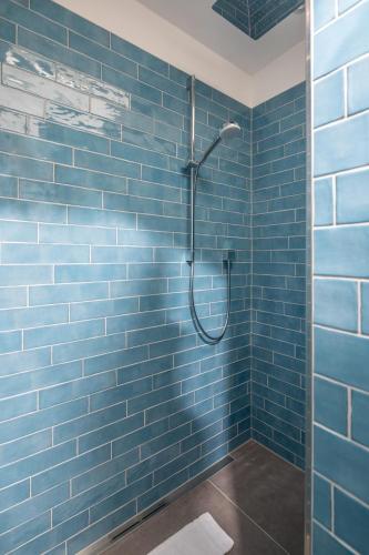 a bathroom with a shower with blue tiles at Haus Lola in Norderney