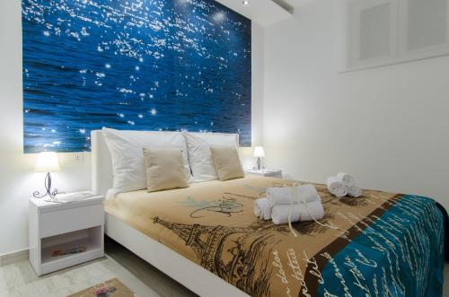 een slaapkamer met een bed met een schilderij aan de muur bij Apartment Carmen in Trogir