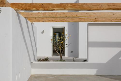 a room with a window in a white wall at Alio Naxos Luxury Suites in Agios Georgios