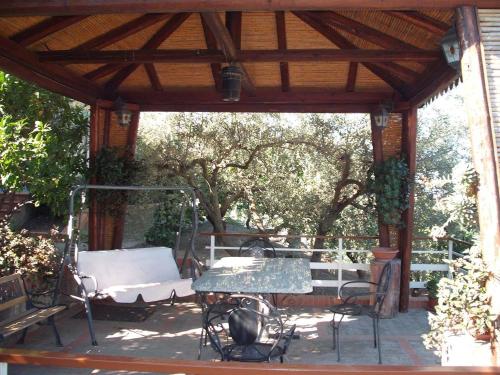 a wooden gazebo with a table and a bench at B&B Villa Rosalia in Barrafranca
