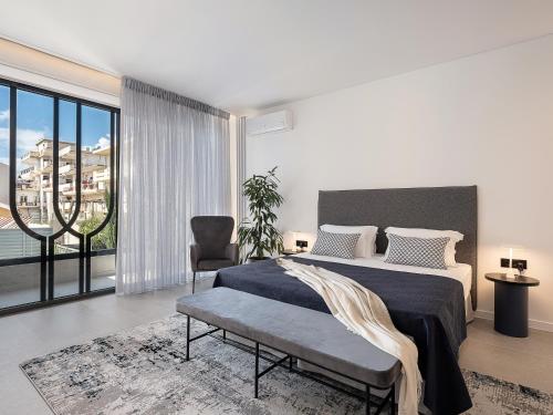 Un dormitorio con una cama y una ventana grande. en JnV Luxury Villas, en La Canea